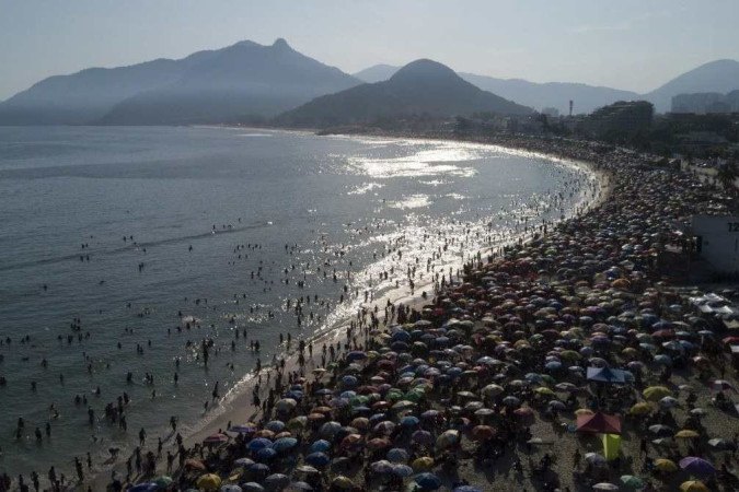 Vista aérea da praia no Recreio dos Bandeirantes, no Rio de Janeiro: forte calor obrigou os cariocas a procurarem um refresco no mar. Pelo menos mais cinco estados registraram máximas acima da média       -  (crédito: Tércio Teixeira/AFP)
