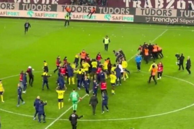 Torcedores do Trabzonspor invadem gramado e brigam com jogadores do Fenerbahce - (crédito: Foto: Reprodução) Torcedores do Trabzonspor invadem gramado e brigam com jogadores do Fenerbahce - (crédito: Foto: Reprodução)