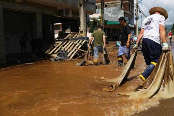 Moradores locais tentam retirar água após enchentes causadas por fortes chuvas, em Roca Sales, estado do Rio Grande do Sul, Brasil, em 19 de novembro de 2023.       Caption  -  (crédito: SILVIO AVILA / AFP)