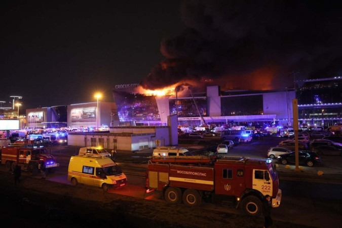 Veículos dos serviços de emergência são vistos do lado de fora de uma casa de shows Crocus City Hall em chamas após o tiroteio em Krasnogorsk, nos arredores de Moscou, em 22 de março de 2024 -  (crédito: STRINGER/AFP)