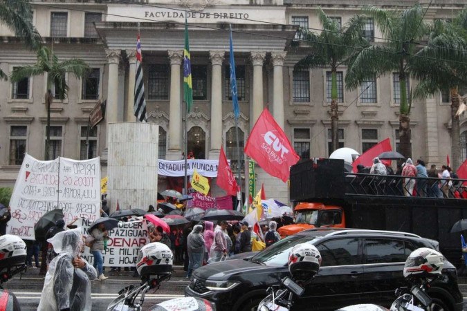 Manifestantes sob chuva protestaram no Largo São Francisco, em São Paulo, pela democracia e contra anistia para envolvidos no 8 de janeiro -  (crédito: Rovena Rosa/Agência Brasil)