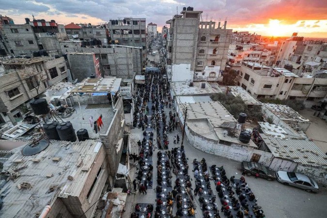 Palestinos partilham o iftar, a refeição feita depois do jejum do Ramadã, o mês sagrado do islamismo, em Rafah, no sul da Faixa de Gaza  -  (crédito: Mohammed Abed/AFP)