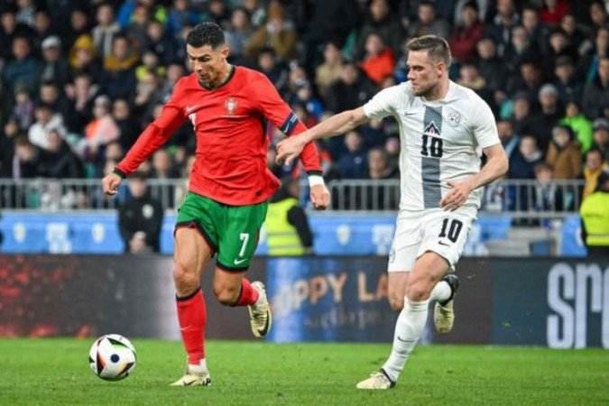 Cristiano Ronaldo em disputa de bola com Timi Elsnik, da Eslovênia - Foto: Jure Makovec/AFP via Getty Images -  (crédito: Foto: Jure Makovec/AFP via Getty Images)