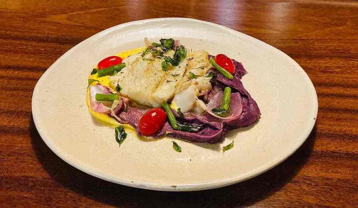 St. Petter grelhado, acompanhado de musseline de mandioquinha e batata doce roxa, tomates-cereja e cebola pérola confitados e banhados ao molho de champanhe.