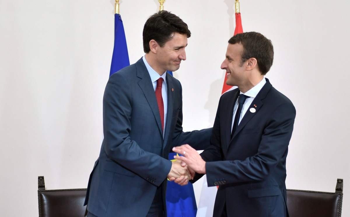 O primeiro-ministro canadense, Justin Trudeau (L), e o presidente francês, Emmanuel Macron, apertam as mãos durante uma reunião bilateral enquanto participam da Cúpula dos Chefes de Estado e de Governo do G7, o grupo das economias mais industrializadas, mais a União Europeia, em maio. 26 de outubro de 2017 em Taormina, Sicília