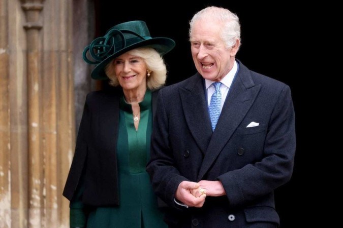  O rei Charles III da Grã-Bretanha, seguido pela rainha da Grã-Bretanha Camilla, reage ao deixar a Capela de São Jorge, no Castelo de Windsor, após participar do Culto de Páscoa, em 31 de março de 2024.  -  (crédito: Hollie Adams / POOL / AFP)