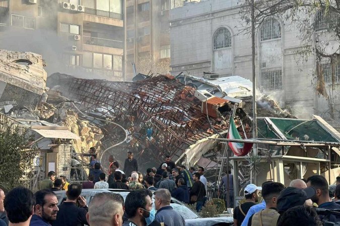 Socorristas inspecionam escombros do prédio anexo ao consulado iraniano, após bombardeio, em Damasco  -  (crédito: Maher Al Mounes/AFP)