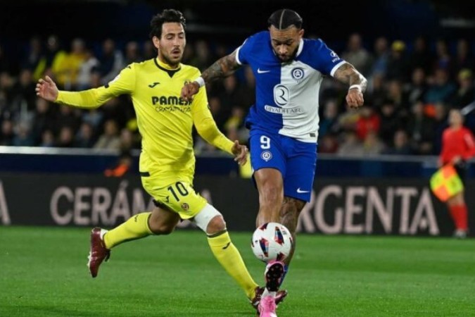 Depay ( de azul e branco) tenta dominar a bola para o Atlético de Madrid. Parejo, do Villarreal, se aproxima para a marcação -  (crédito: Foto: Jose Jordan/AFP via Getty Images)