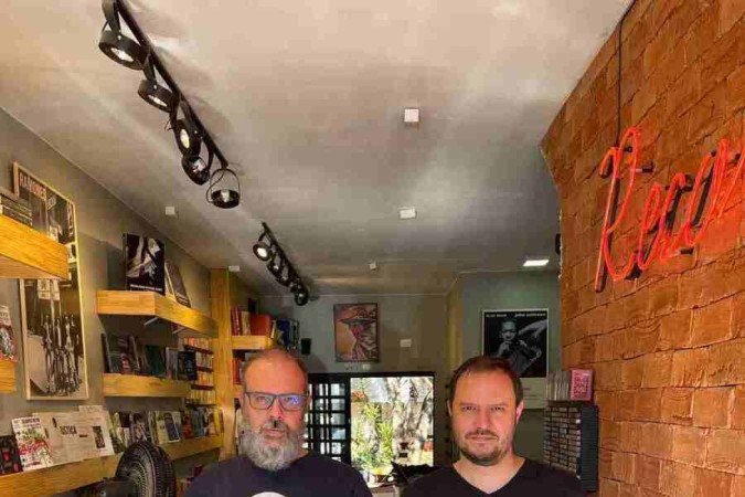 João (óculos e barba) e Gustavo segurando um dos discos mais raros do Brasil, Rosa de Sangue, de Lula Côrtes