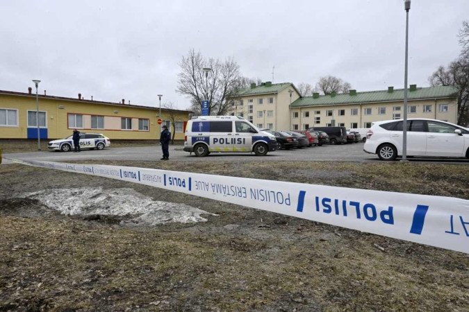 Policiais finlandeses guardam a cena por trás de fitas policiais na escola primária de Viertola, onde uma criança abriu fogo e feriu outras três crianças, em 2 de abril de 2024, em Vantaa, nos arredores da capital finlandesa, Helsinque -  (crédito: Markku Ulander / Lehtikuva / AFP)
