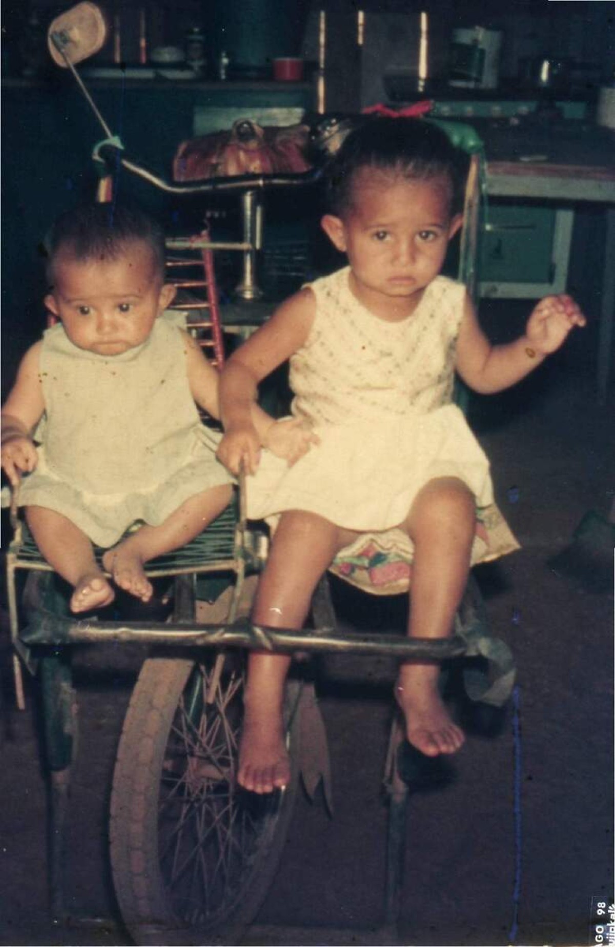 Gina Vieira Ponte de Albuquerque, à esquerda, aos 10 meses, em cima da bicicleta que o pai usava para vender bolachões e sustentar a família