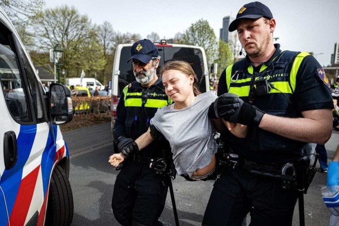 A ativista climática sueca Greta Thunberg é presa durante uma marcha climática contra os subsídios fósseis perto da rodovia A12 em Haia, em 6 de abril de 2024       -  (crédito: Ramon van Flymen / ANP / AFP)