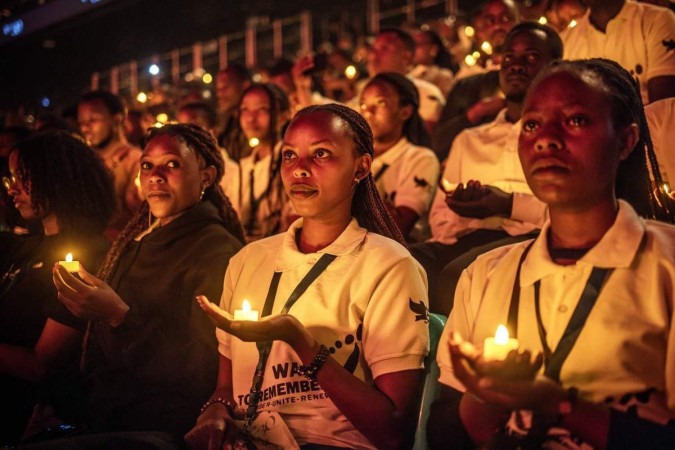 Jovens ruandeses seguram velas sem chama enquanto participam de uma vigília durante as comemorações do 30º aniversário do genocídio ruandês de 1994, na Arena BK, em Kigali, em 7 de abril de 2024 -  (crédito: LUIS TATO/AFP)