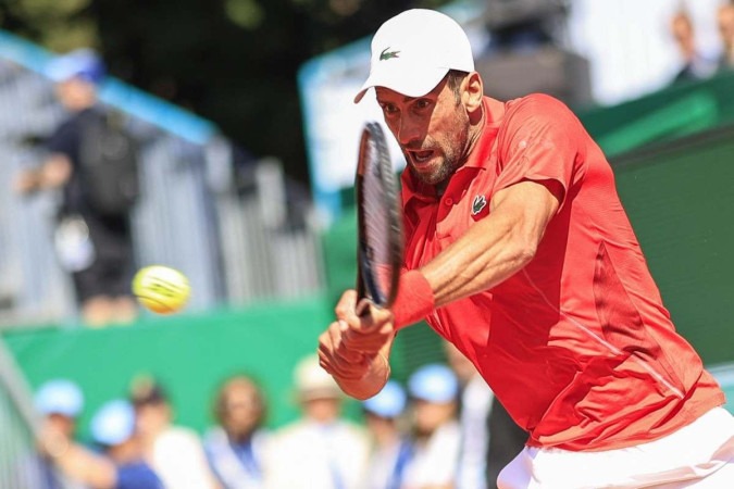 O sérvio Novak Djokovic devolve o backhand ao italiano Lorenzo Musetti durante a partida de tênis das oitavas de final do Monte Carlo -  (crédito: Valery HACHE / AFP)