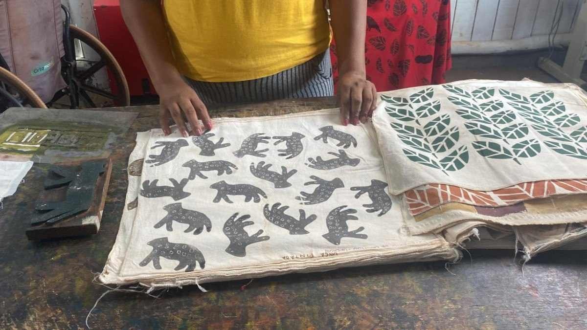 Artesãs fazem produtos de tecido com tintas e desenhos que elas produzem