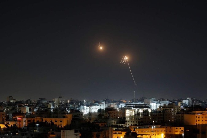 Raios de luz são vistos enquanto o sistema de defesa aérea Iron Dome de Israel intercepta foguetes disparados da Faixa de Gaza para o território israelense em 7 de abril de 2023 -  (crédito: MOHAMMED ABED / AFP)