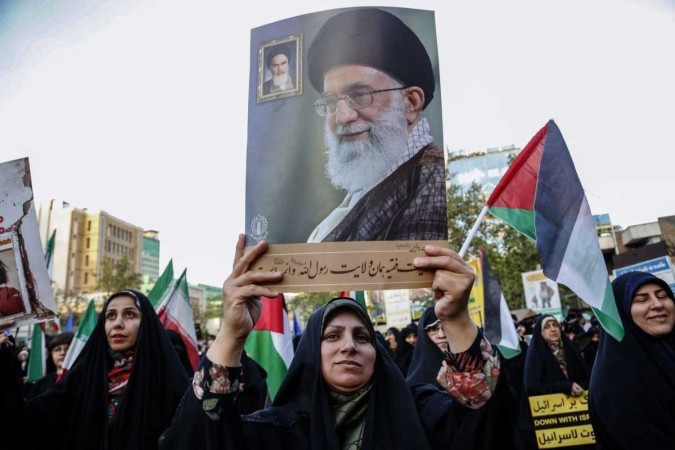 Em Teerã, mulher exibe foto do aiatolá Ali Khamenei durante celebração por ataque -  (crédito:  AFP)