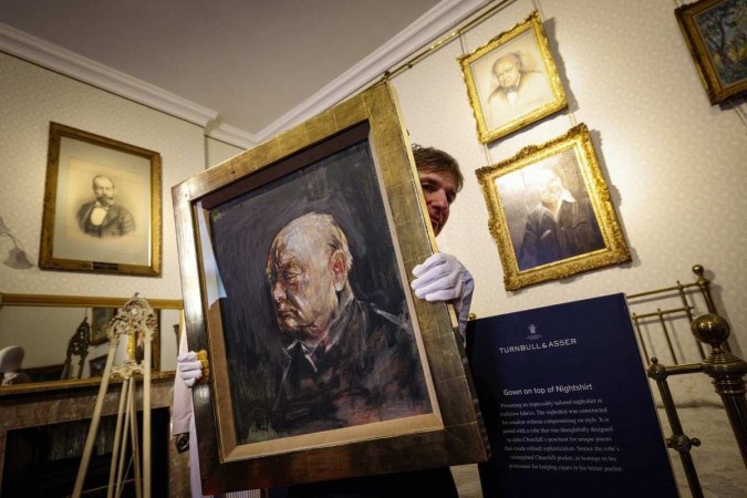 Matthew Floris, funcionário da Sotheby's, posa com um retrato, um estudo sobrevivente de Winston Churchill no quarto onde Churchill nasceu no Palácio de Blenheim -  (crédito: Adrian DENNIS / AFP)