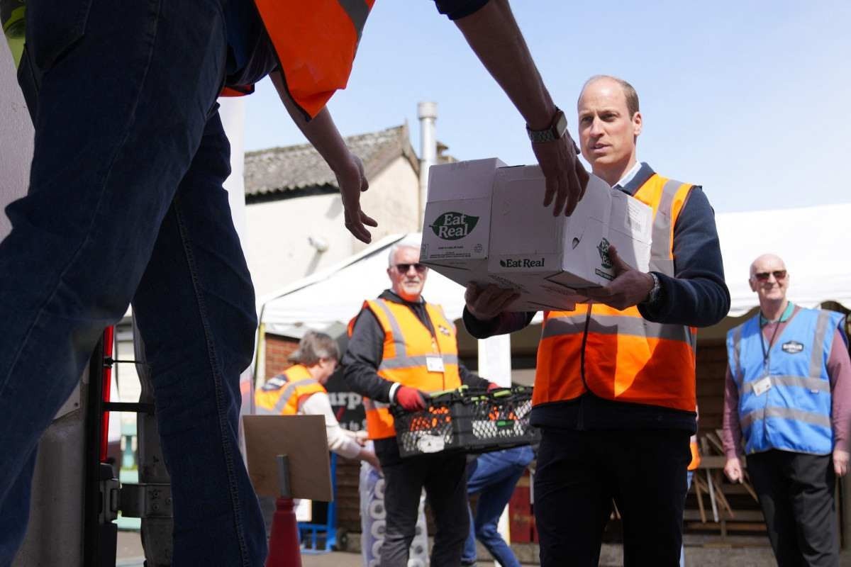  Britains Prince William, Prince of Wales helps to loads trays of food into vans during a visit to Surplus to Supper, a surplus food redistribution charity, in Sunbury-on-Thames, Surrey, England, on April 18, 2024. (Photo by Alastair Grant / POOL / AFP)       