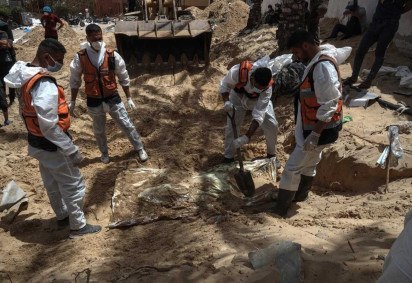 Profissionais de saúde desenterram corpos encontrados no Hospital Nasser em Khan Yunis, no sul da Faixa de Gaza, em 23 de abril de 2024 -  (crédito:  AFP)
