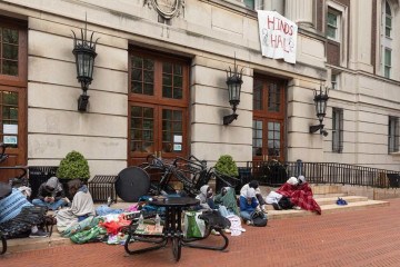 Com os rostos e corpos cobertos, universitários bloquearam a entrada de Hamilton Hall com mesas: sem negociação -  (crédito:  AFP)