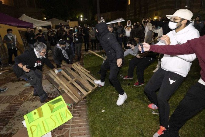  Counter protesters attack pro-Palestinian protesters at a pro-Palestinian encampment set up on the campus of the University of California Los Angeles (UCLA) as clashes erupt, in Los Angeles on May 1, 2024. Clashes broke out on May 1, 2024 around pro-Palestinian demonstrations at the University of California, Los Angeles, as universities around the United States struggle to contain similar protests on dozens of campuses. (Photo by ETIENNE LAURENT / AFP)
      Caption 