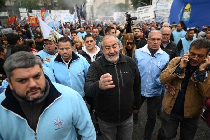  Hector Daer (C), the general secretary of the General Confederation of Labor (CGT), walks escorted by his bodyguards during a May Day (Labor Day) demonstration in Buenos Aires on May 1, 2024. (Photo by Luis ROBAYO / AFP)
      Caption 