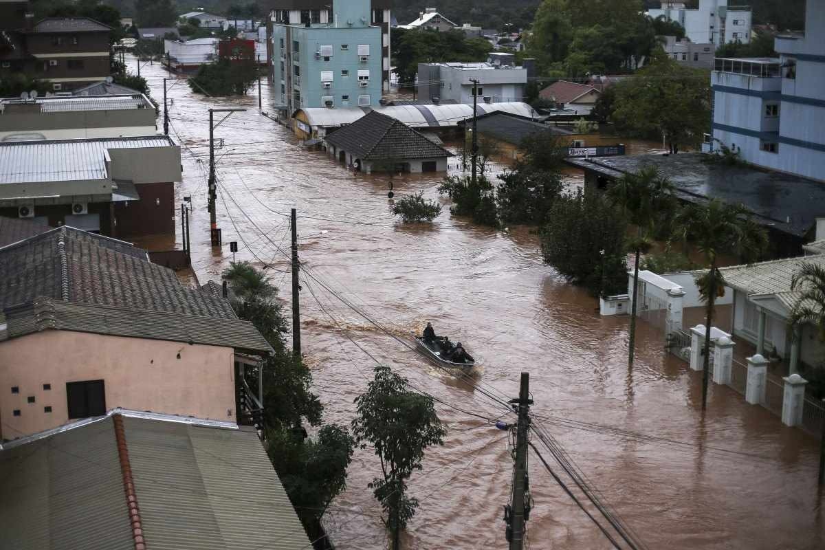  Volunteers use a fishing boat to rescue residents trapped inside their houses at the city center of Sao Sebastiao do Cai, Rio Grande do Sul state, Brazil on May 2, 2024. The death toll from a severe storm in Rio Grande do Sul, in southern Brazil, rose to 13, amid the 