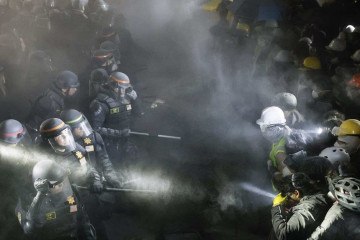 Policiais enfrentam estudantes pró-Palestina após destruírem parte da barricada erguida no câmpus da UCLA, em Los Angeles  -  (crédito: Etienne Laurent/AFP)