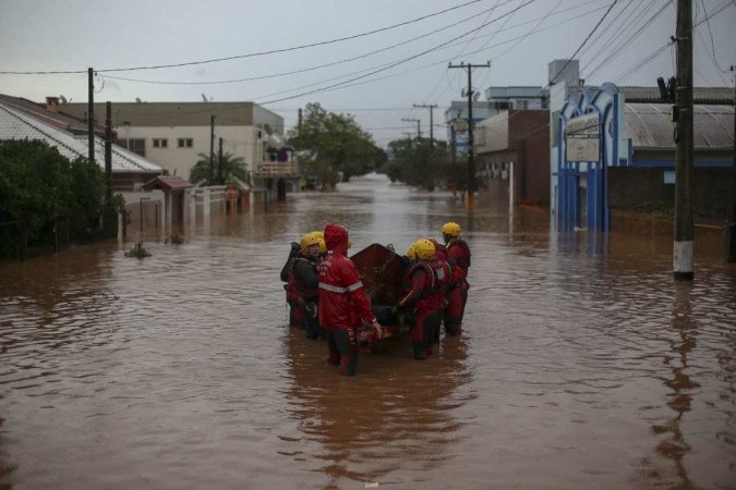 Uma equipe de bombeiros trabalha em uma rua inundada no centro da cidade de São Sebastião do Cai, Rio Grande do Sul, Brasil, em 2 de maio de 2024       -  (crédito: ANSELMO CUNHA / AFP)
