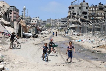 Crianças  transitam em rua devastada pelos bombardeios israelenses, na Cidade de Gaza: após a guerra, a difícil missão de controlar território -  (crédito: AFP)