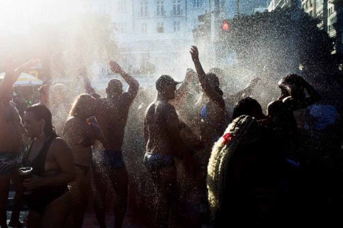 Fãs da estrela pop norte-americana Madonna cantam e dançam enquanto bombeiros borrifam água para refrescar o público na praia de Copacabana antes de um mega show gratuito para encerrar sua turnê Celebration no Rio de Janeiro, Brasil, em 4 de maio de 2024.