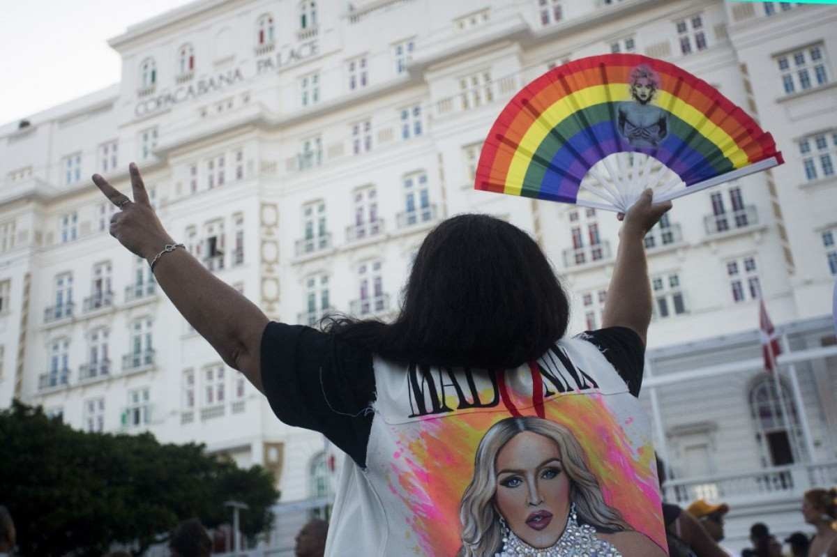 Uma fã da estrela pop norte-americana Madonna saúda o hotel Copabana Palace antes de um mega show gratuito na praia de Copacabana para encerrar sua turnê Celebration no Rio de Janeiro, Brasil, em 4 de maio de 2024.       