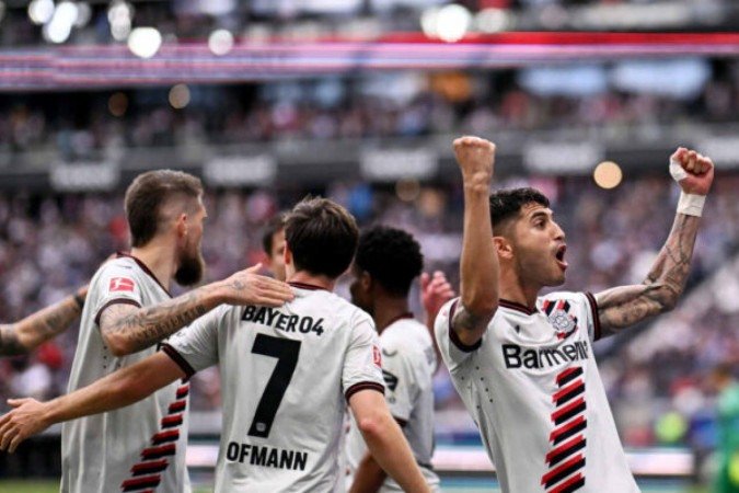 Exequiel Palacios levanta os braços e celebra o seu gol, o terceiro do Leverkusen sobre o Eintracht - (crédito: Foto: Kirill Kudryavtsev/AFP via Getty Images) Exequiel Palacios levanta os braços e celebra o seu gol, o terceiro do Leverkusen sobre o Eintracht - (crédito: Foto: Kirill Kudryavtsev/AFP via Getty Images)