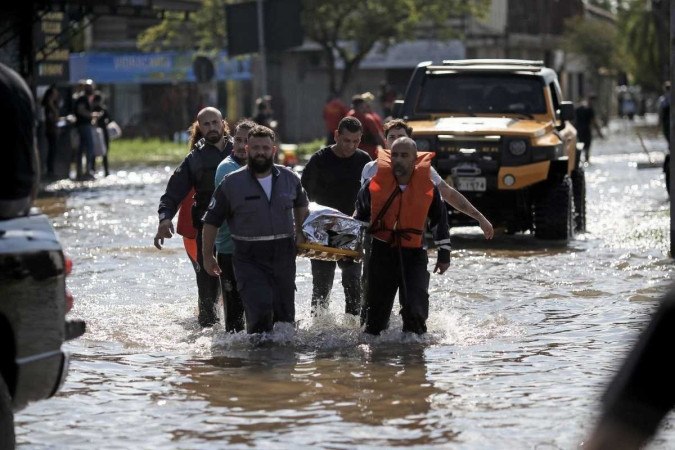 Uma mulher é transportada para um centro médico após ser resgatada no bairro Sarandi, em Porto Alegre, Rio Grande do Sul, Brasil, em 5 de maio de 2024       -  (crédito: ANSELMO CUNHA / AFP)