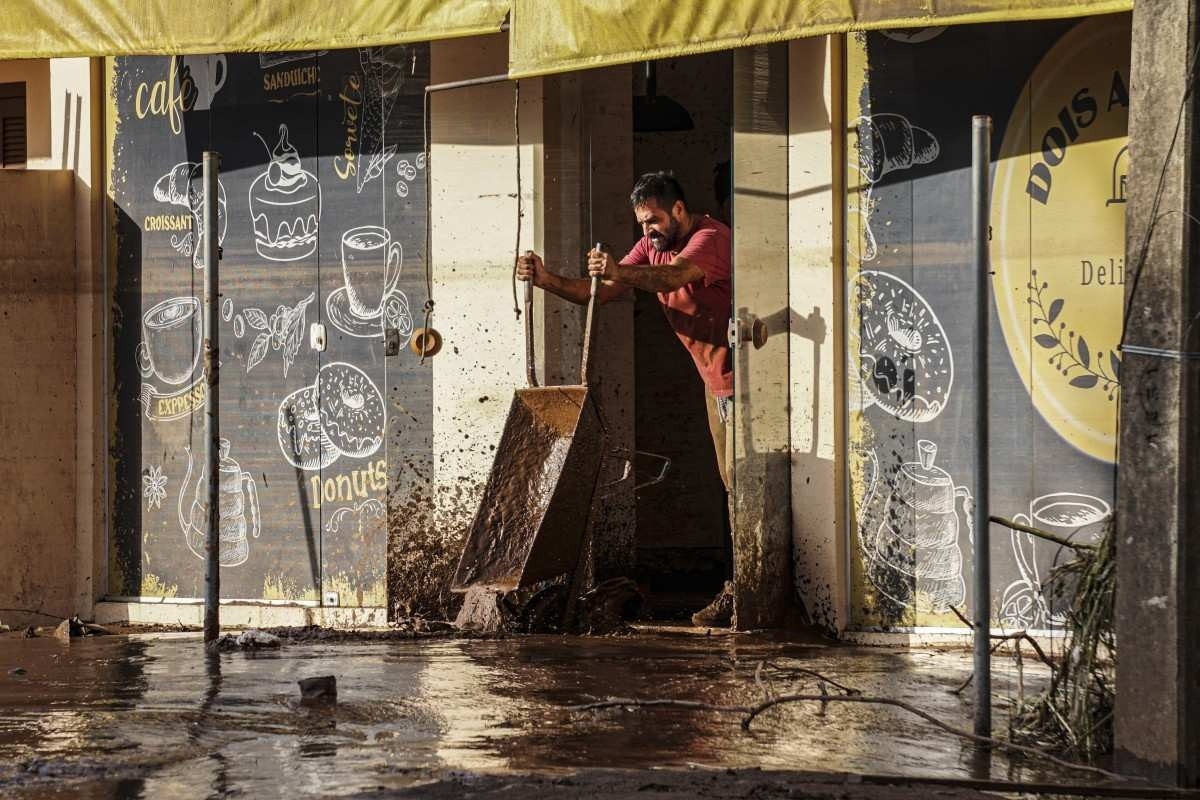 Um homem remove a lama deixada pelas enchentes de uma loja em Roca Sales, estado do Rio Grande do Sul, Brasil, em 5 de maio de 2024      