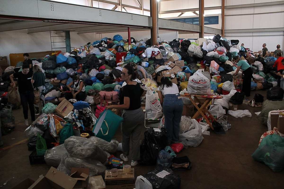Acima, mulheres de militares separam roupas na FAB e doações de colchões e de água chegando na Base Aérea de Brasília 