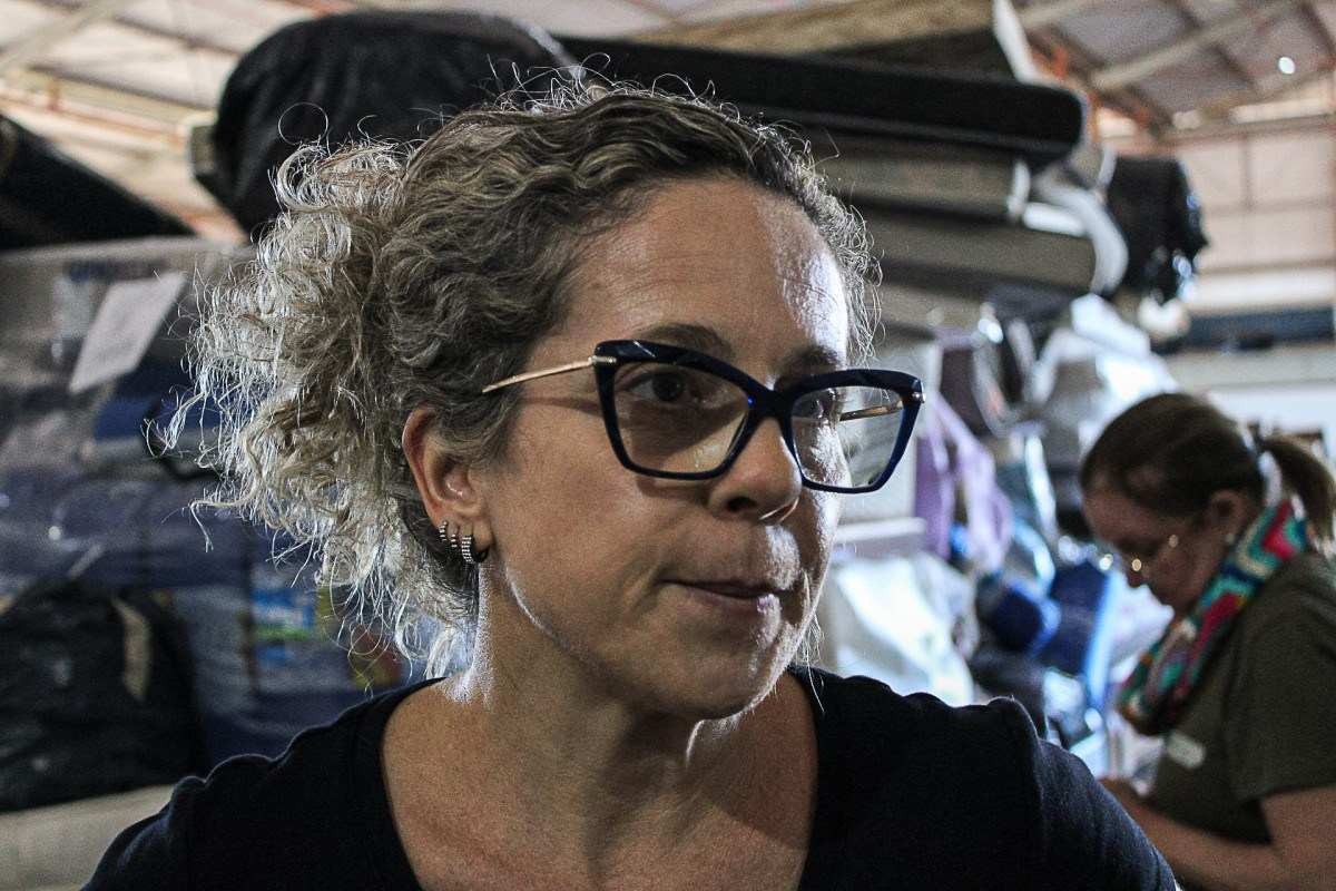 Viviane Diamantino ajuda outras mulheres de militares a ordenar as roupas e outras doações