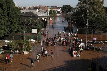 An aerial view shows volunteers and first responders working on rescue operations at a flooded area in the Sao Joao neighborhood of Porto Alegre, Rio Grande do Sul state, Brazil, on May 7, 2024. Since the unprecedented deluge started last week, at least 85 people have died and more than 150,000 were ejected from their homes by floods and mudslides in Rio Grande do Sul state, authorities said. (Photo by ANSELMO CUNHA / AFP)
     -  (crédito:  AFP)