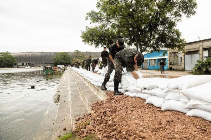 Policiais da Brigada Militar empilham sacos de areia para evitar que as águas da Lagoa dos Patos inundem Pelotas  -  (crédito:  Michel Corvello)