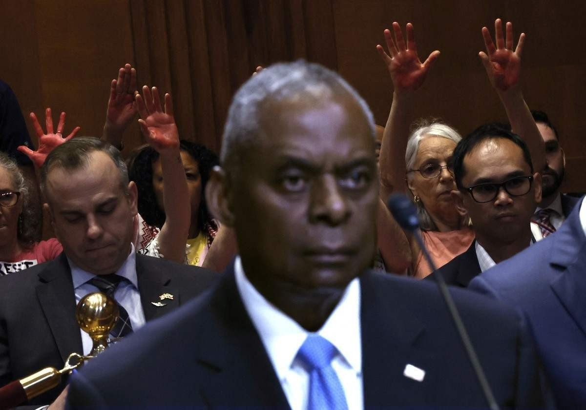 Manifestantes mostram mãos cobertas de tinta vermelha durante audiência de Loyd Austin no Congresso 