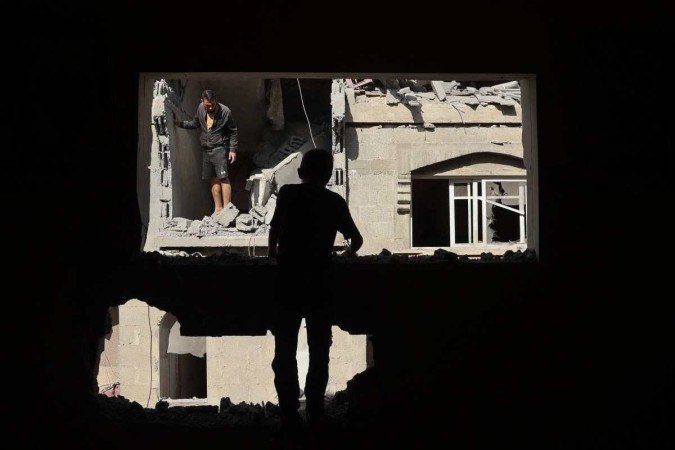 Palestinos inspecionam os danos provocados por bombardeio israelense em uma casa, na cidade de Rafah
