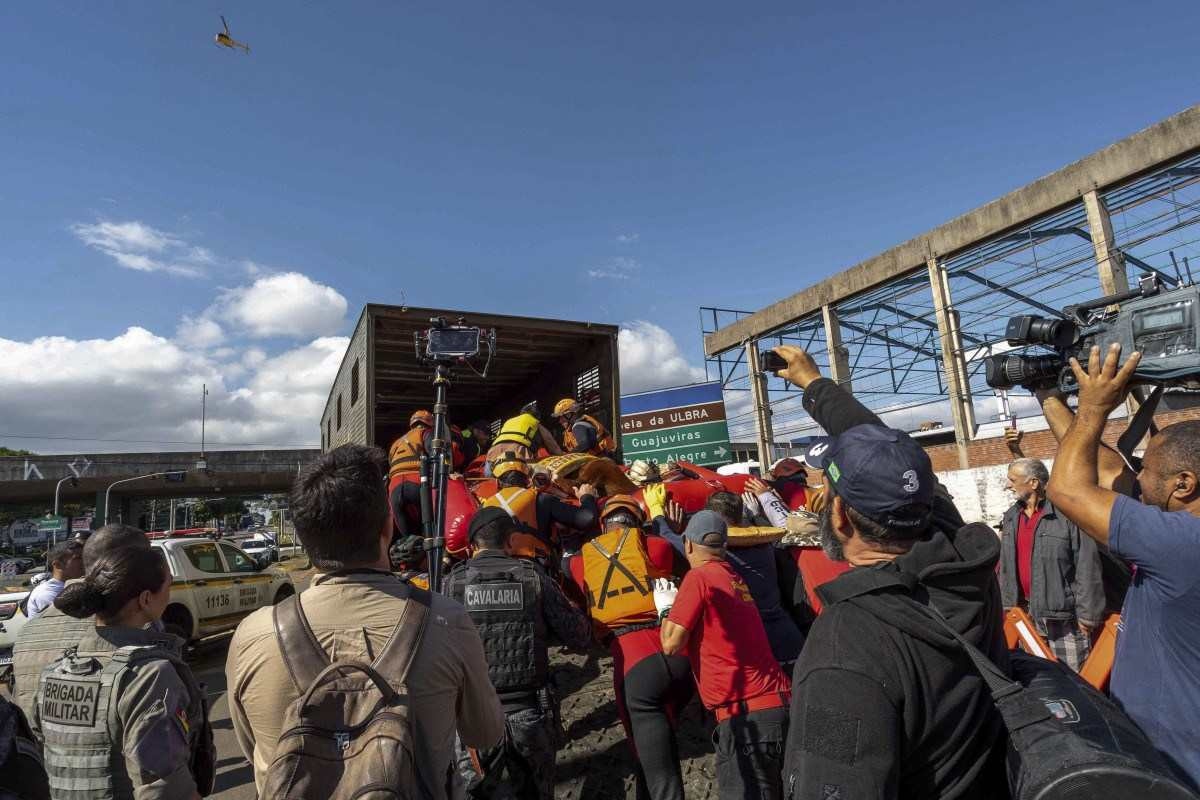 Esta foto divulgada pela Prefeitura de Canoas mostra bombeiros e voluntários carregando um cavalo que foi resgatado do telhado de uma casa em um caminhão na cidade de Canoas, Rio Grande do Sul, Brasil, em 9 de maio de 2024.