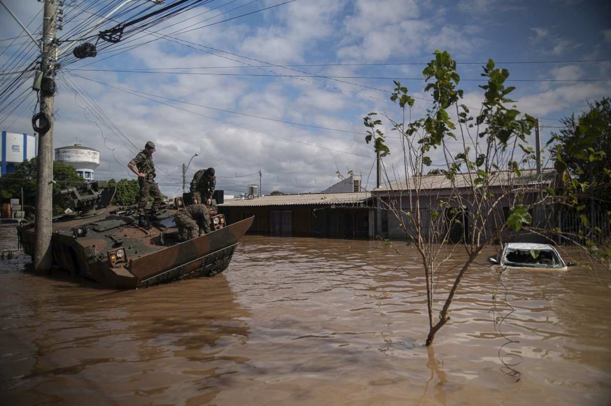 Soldados do Exército observam seu veículo danificado em uma rua inundada de Eldorado do Sul, no Rio Grande do Sul
