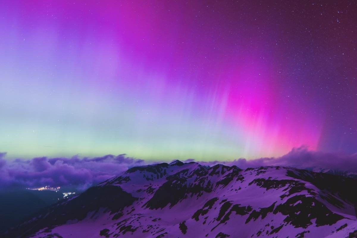 A aurora boreal ou aurora boreal iluminam o céu noturno sobre Fusch an der Grobglocknerstrabe, perto de Zell am See (na Áustria), durante uma tempestade geomagnética em 11 de maio de 2024