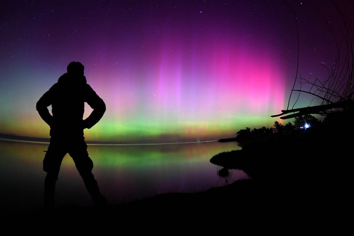 A Aurora Australis, também conhecida como Luzes do Sul, brilha no horizonte sobre as águas do Lago Ellesmere, nos arredores de Christchurch, em 11 de maio de 2024.