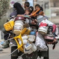Família de palestinos abandona Rafah a bordo de triciclo carregado com todos os seus pertences: cena cada vez mais comum no enclave -  (crédito: AFP)