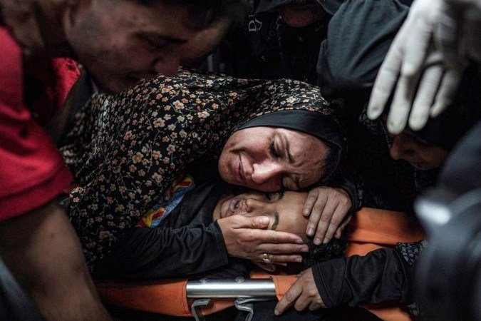 M&atilde;e chora sobre o corpo do filho, morto durante bombardeio a um campo de refugiados, em  Deir Al-Balah
