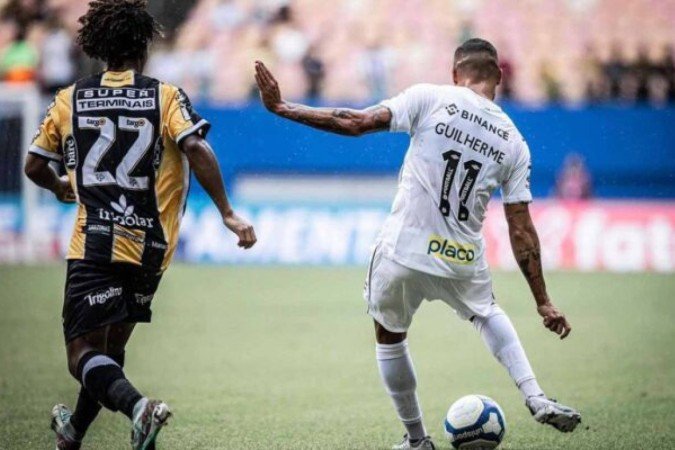 Guilherme tenta a finalização para o Santos diante da marcação de Ênio. Mas sem sucesso - (crédito: Foto: Raul Baretta/ Santos FC.) Guilherme tenta a finalização para o Santos diante da marcação de Ênio. Mas sem sucesso - (crédito: Foto: Raul Baretta/ Santos FC.)
