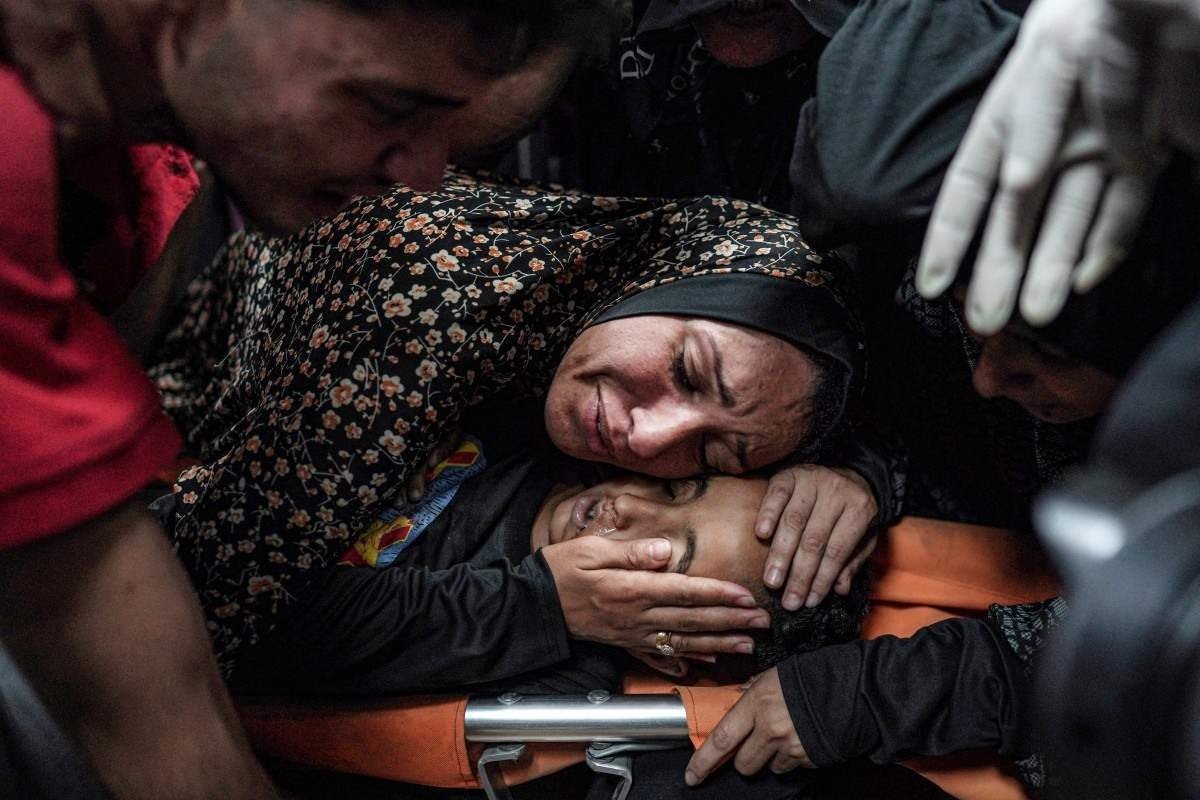Palestina chora sobre o corpo do filho morto, após bombardeio a um campo de refugiados em Deir Al Balah, no centro de Gaza 